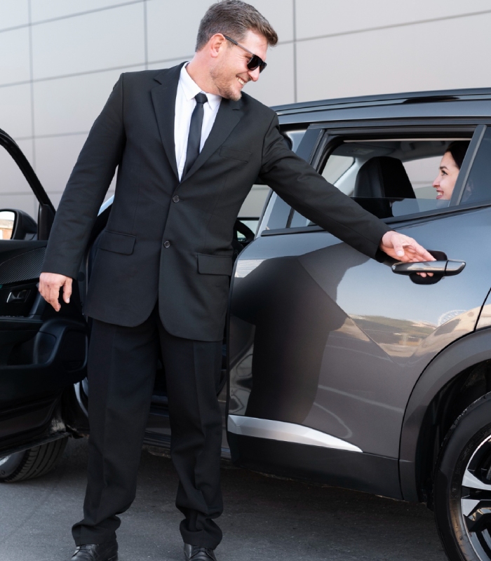 Chauffeur ouvrant la porte d’un véhicule pour une cliente